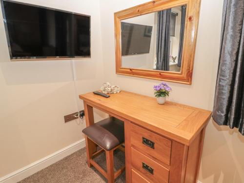 a wooden desk with a mirror and a chair at River Cottage in Morpeth