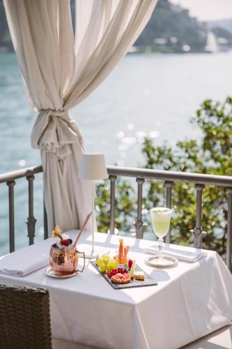 a white table with food and drinks on a balcony at Hotel Villa Flori in Como