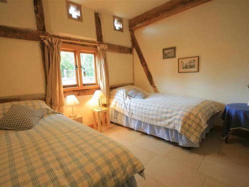 a bedroom with two beds and a window at Whites Farm Barn in Ledbury