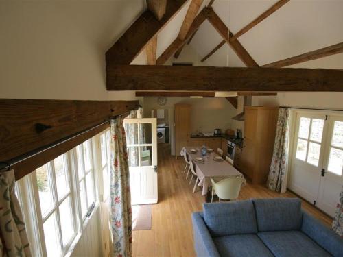 Upper Mill Barn في Quenington: غرفة معيشة مع أريكة زرقاء وطاولة