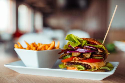 a sandwich on a plate next to a bowl of fries at Hotel Picaro Kopytkowo A1 in Kopytkowo