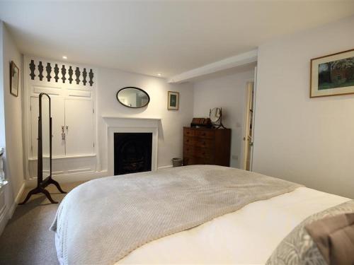 a white bedroom with a bed and a fireplace at Hare House in Chipping Norton