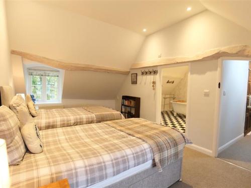 ein Schlafzimmer mit 2 Betten und ein Badezimmer in der Unterkunft Hare House in Chipping Norton