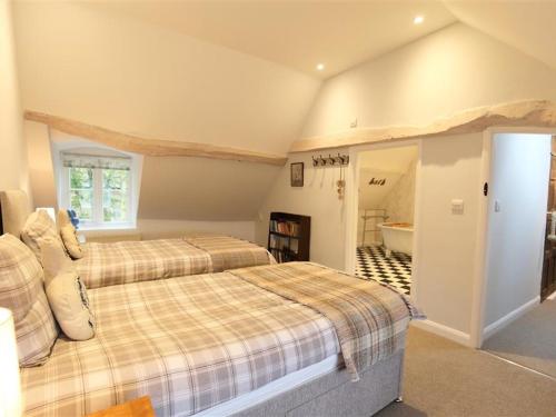 a bedroom with two beds and a bathroom at Hare House in Chipping Norton