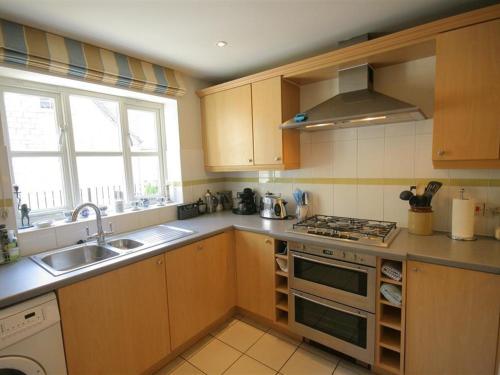 a kitchen with a sink and a stove top oven at Batemans in Nailsworth