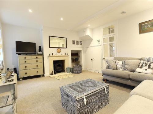 a living room with a couch and a fireplace at Hare House in Chipping Norton