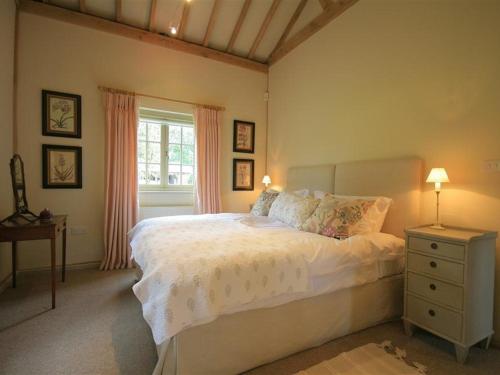 a bedroom with a white bed and a window at West Barn in Woodstock