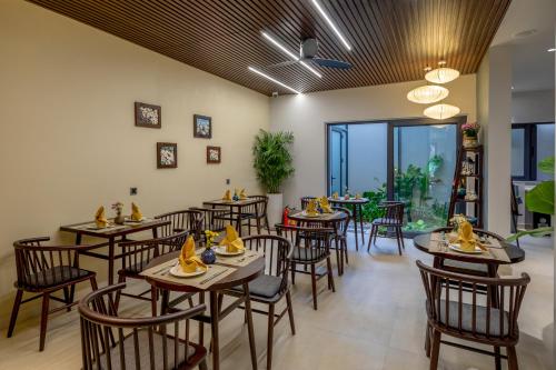 ホイアンにあるVolar de Faifo Villaの部屋にテーブルと椅子があるレストラン