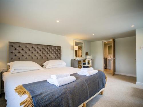 a bedroom with a large bed with towels on it at The Granary in Bledington