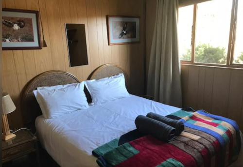 a bedroom with a bed with a blanket on it at Fly Shack in Dullstroom
