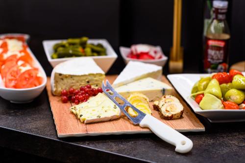 einen Tisch mit einer Tafel mit Käse und Obst in der Unterkunft Alpenhotel Weiherbach Berchtesgaden Hallenbad und Sauna in Berchtesgaden