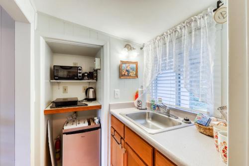 uma pequena cozinha com um lavatório e uma janela em Redwood Roost em Arcata
