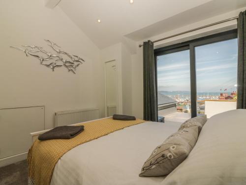 1 dormitorio con cama y ventana grande en Harbour View Retreat en Brixham