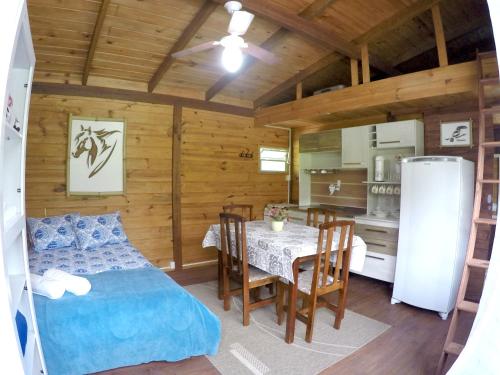 um quarto com uma cama, uma mesa e uma cozinha em Ada Verde em Rio dos Cedros