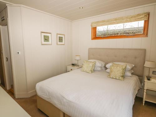 a bedroom with a white bed and a window at Hambleton in Cottesmore