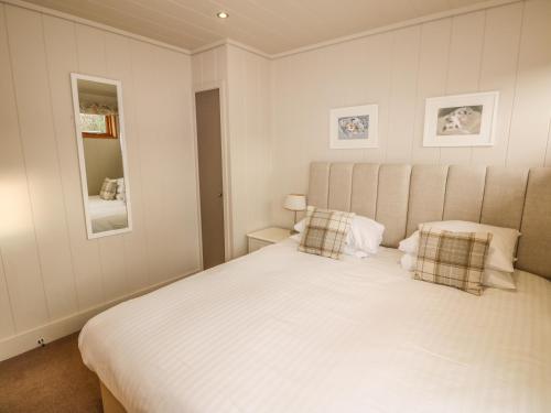 a bedroom with a large white bed with two pillows at Hambleton in Cottesmore