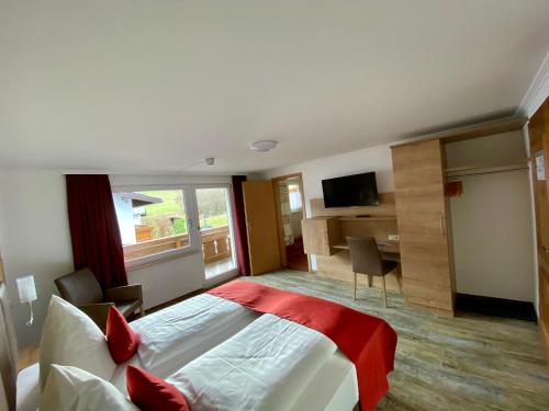 a hotel room with a large bed and a desk at Alpenhotel Weiherbach Berchtesgaden Hallenbad und Sauna in Berchtesgaden