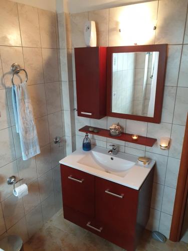 a bathroom with a sink and a mirror and a shower at Villa Aegean Balcony in Akhladherí