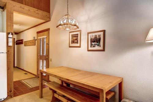 a dining room with a wooden table and a chandelier at Ski-InandSki-Out Northstar Condo Near Lake Tahoe! in Truckee