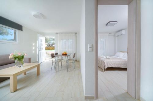 Habitación blanca con cama y mesa en Ilias Apartments, en Chrysi Ammoudia