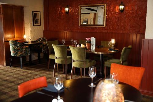 un restaurante con mesas y sillas y copas de vino en The Rising Sun en Coltishall