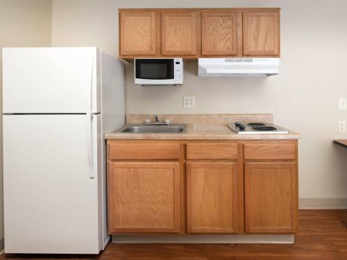 
a kitchen with a refrigerator, stove, sink and microwave at WoodSpring Suites Wilkes-Barre in Wilkes-Barre
