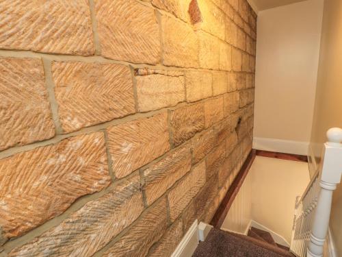 a faux stone wall in a room with a staircase at Street House Farm Cottage in Saltburn-by-the-Sea