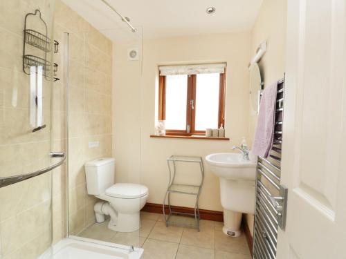 ein Badezimmer mit Toilette, Waschbecken und Dusche in der Unterkunft Gerand in Windermere