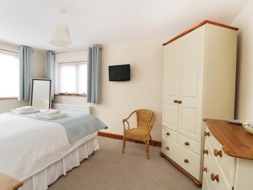 ein Schlafzimmer mit einem weißen Bett und einer Kommode in der Unterkunft Gerand in Windermere