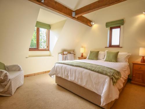 a bedroom with a large bed and two windows at The Coach House in Exmouth