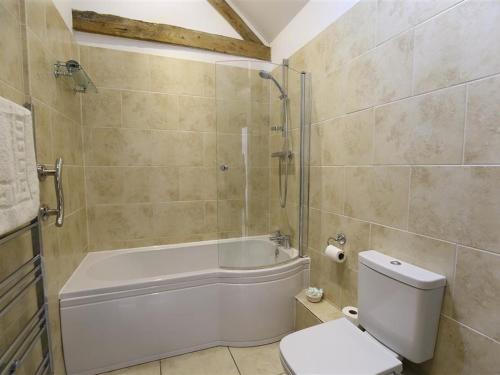 uma casa de banho com uma banheira, um WC e um chuveiro em The Old Dairy em Westbury on Severn
