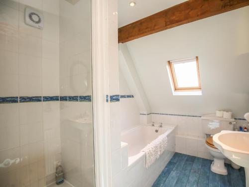 a bathroom with a tub and a sink at The Coach House in Exmouth