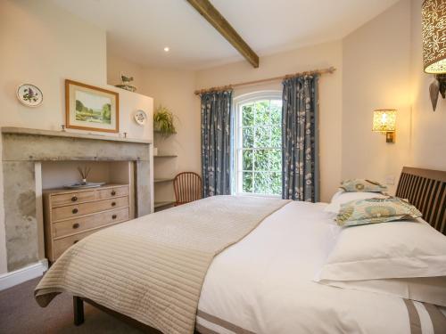 West Lodge في Rockbourne: غرفة نوم بسرير ومدفأة