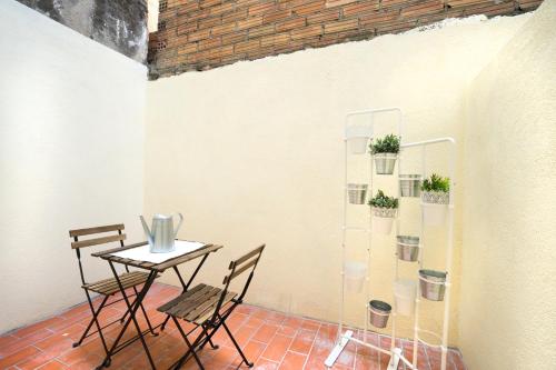 a table and chairs in a room with a wall at Hotelito Boutique Mercat in Hospitalet de Llobregat