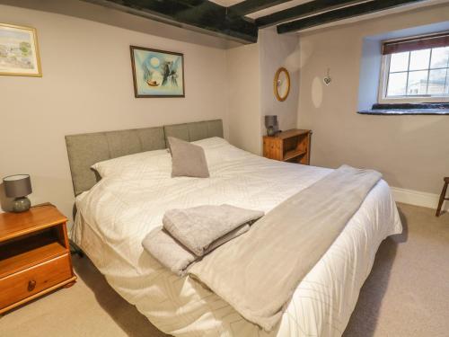 a bedroom with a white bed with two pillows on it at Pengwern in Pennant-Melangell
