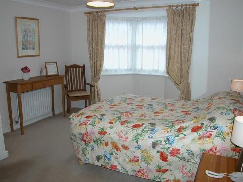 a bedroom with a bed and a desk and a window at Charter Court in Salisbury