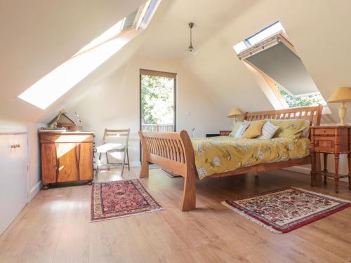 a bedroom with a bed and a desk in a attic at The Lookout in Llangarren