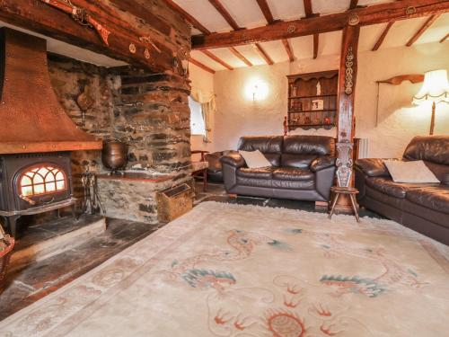 a living room with a couch and a fireplace at Pengwern in Pennant-Melangell
