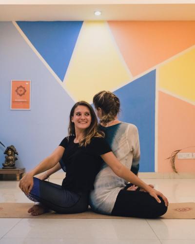 two women sitting on the floor in front of a wall at AmigosIndia in New Delhi