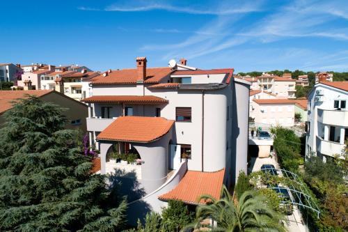 a white house with an orange roof at Vratovic Apartments in Pula