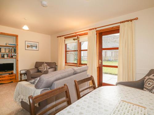 a living room with a couch and a table at Church House in Poolewe