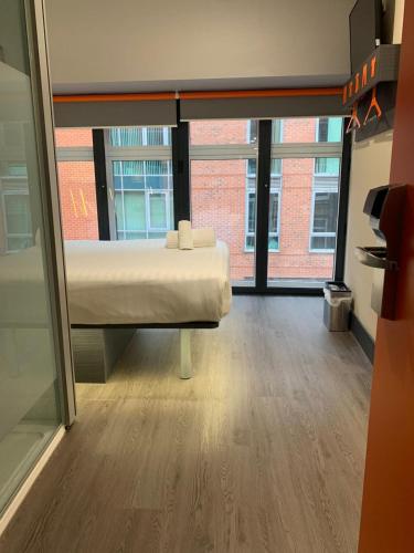 a room with a bed and a large window at easyHotel Birmingham in Birmingham
