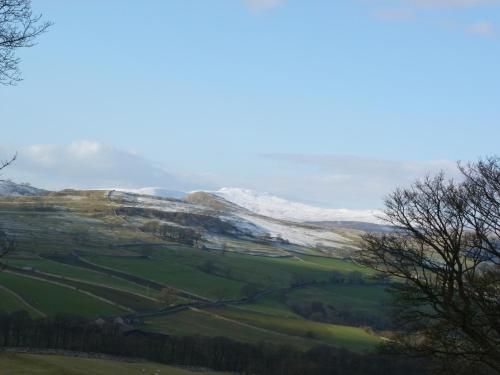 a view of a snow covered mountain with green fields at Melsome Barn in Settle