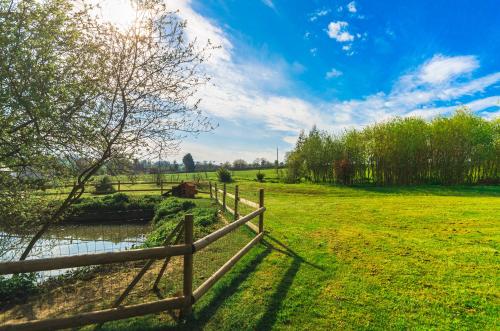 a wooden fence in a field with a horse in the background at la ferme des epis in Ouffières