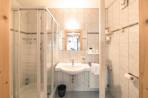 a white bathroom with a sink and a shower at Residenz am Kaiserweg in Longomoso