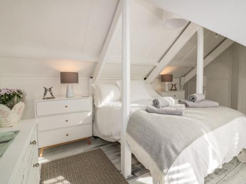 メバギシーにあるHarbour Retreatの白いベッドルーム(ベッド2台、ドレッサー付)