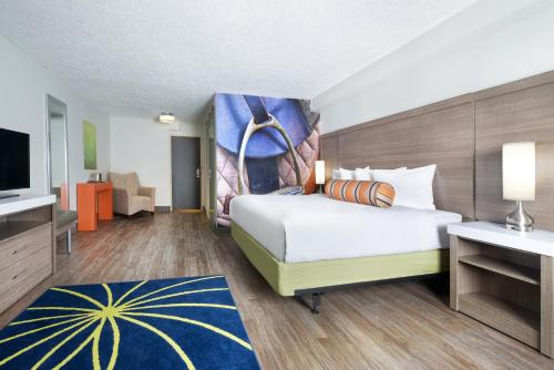 a hotel room with a bed and a flat screen tv at Hotel Indigo Cleveland Beachwood, an IHG Hotel in Beachwood