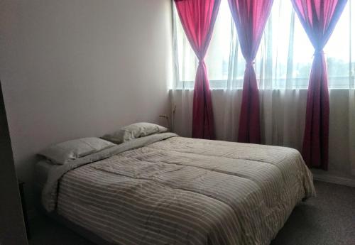 a bedroom with a bed with pink curtains and a window at Viña del mar descanso y entretención in Viña del Mar