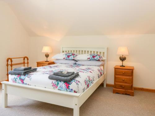 a bedroom with a bed and two lamps at Riverbank House in Roybridge
