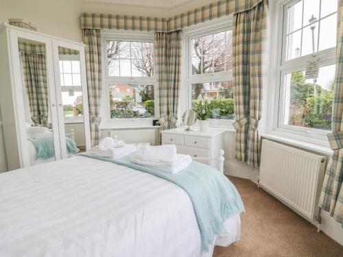 a bedroom with a bed and two windows at Flat 1, Cambridge Court in Frinton-on-Sea